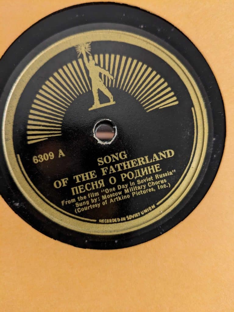 Song of the Fatherland label. Lettering in gold against a black background. Outline of soviet worker at top above spindle.